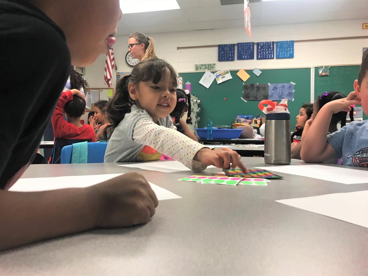 Juliette Diaz Flores reaches for a sticker to add to her art project with her preschool class at Bauder Elementary School in this 2019 file photo.