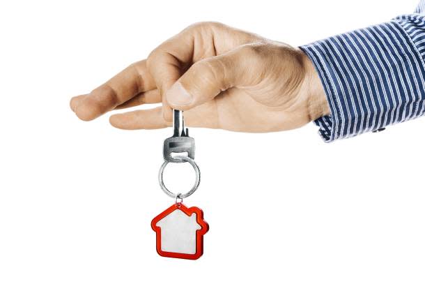 A hand holding out a key for the subletting of a HDB flat 