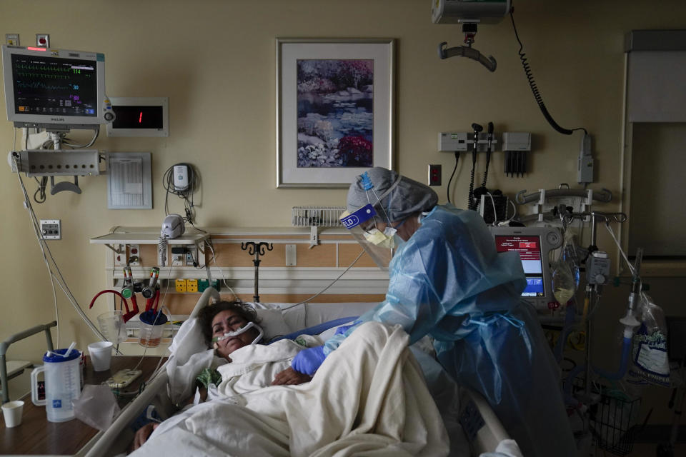 Registered nurse Merri Lynn Anderson, right, tends to her patient in a COVID-19 unit at St. Joseph Hospital in Orange, Calif., Thursday, Jan. 7, 2021. The state's hospitals are trying to prepare for the possibility that they may have to ration care for lack of staff and beds — and hoping they don't have to make that choice as many hospitals strain under unprecedented caseloads. (AP Photo/Jae C. Hong)