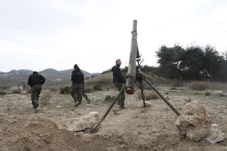 Rebel fighters prepare to launch a Grad long distance shell towards forces loyal to Syria's president Bashar Al-Assad located in the city of Jableh at the Syrian coast, from Jabal al-Akrad area in Syria's northwestern Latakia province December 4, 2014. REUTERS/Alaa Khweled