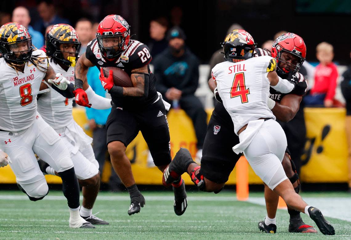 N.C. State offensive lineman Lyndon Cooper (57) blocks Maryland defensive back Tarheeb Still (4) to give N.C. State running back Demarcus Jones II (28) space to run during the second half of Maryland’s 16-12 victory over N.C. State in the Duke’s Mayo Bowl at Bank of America Stadium in Charlotte, N.C., Friday, Dec. 30, 2022.