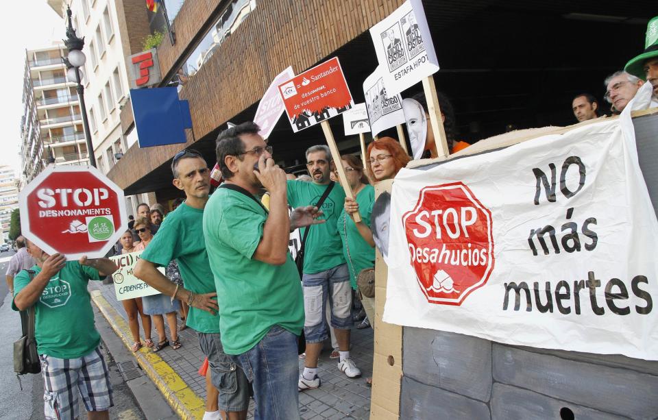 Activists from the Mortgage Victim's Platform take part in a nationwide protest against mortgage loaners UCI, a credit unit of Santander bank and BNP Paribas bank, outside its offices in Valencia, September 6, 2013. The placard reads "No more deaths". REUTERS/Heino Kalis (SPAIN - Tags: BUSINESS SOCIETY CIVIL UNREST)