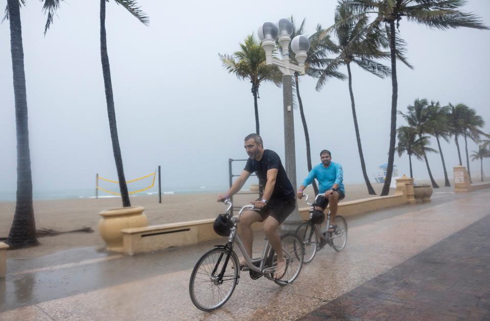 Bicyclists make their down the Hollywood Beach Broadwalk as heavy rain falls over parts of South Florida on Wednesday, June 12, 2024, in Hollywood, Fla. (Matias J. Ocner/Miami Herald via AP)