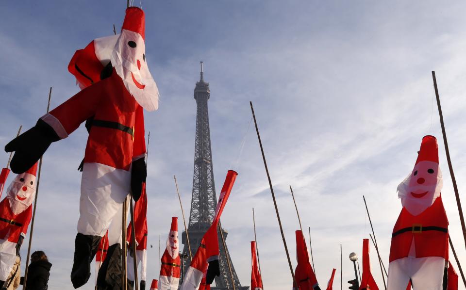 Santa Claus kites float in front of the Eiffel Tower as part of Christmas holiday season preparations in Paris