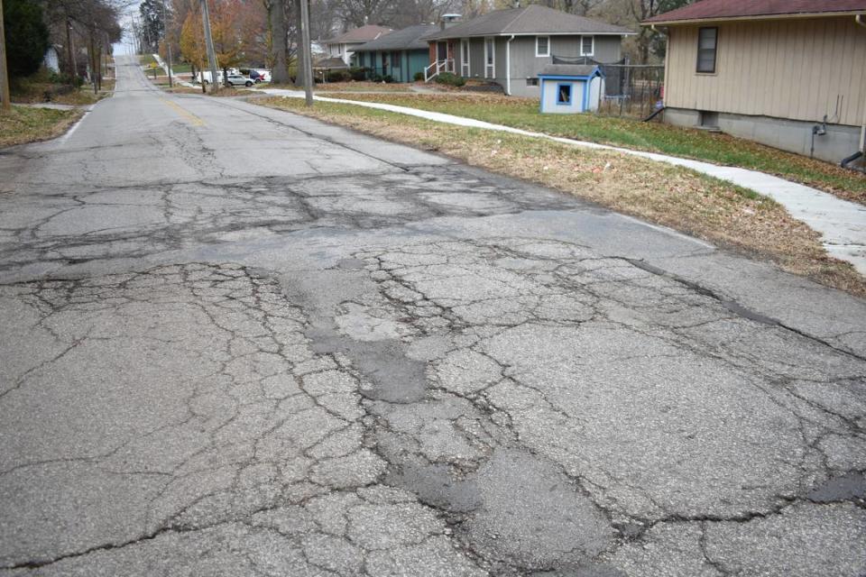 Cracked and patched pavement is seen along 89th Street between Oak Street and Holmes Road in the Santa Fe Hills neighborhood of Kansas City on Thursday, Nov. 30, 2023.