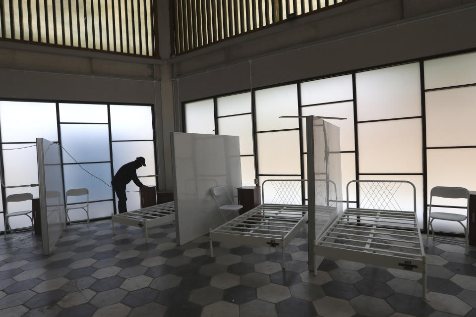 In this April 13, 2020, photo, a worker arranges furniture at a government building that is being prepared to become an emergency hospital for COVID-19 patients in Tangerang, Indonesia. While its neighbors scrambled early this year to try to contain the spread of the new coronavirus, the government of the world’s fourth most populous nation insisted that everything was fine. Only after the first cases were confirmed in March did President Joko Widodo acknowledge that his government was deliberately holding back information about the spread of the virus to prevent the public from panicking. The country now has the the highest death toll in Asia after China. (AP Photo/Tatan Syuflana)