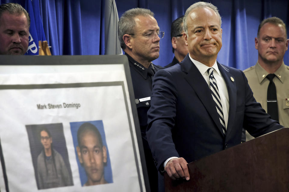 FILE - In this April 29, 2019, file photo, United States Attorney Nick Hanna stands next to photos of Mark Steven Domingo during a news conference in Los Angeles. A federal grand jury has indicted the U.S. Army veteran for allegedly plotting to plant a bomb at a planned rally by white supremacists in California. The U.S. Attorney's office says Wednesday, May 22, 2019, that the indictment charges Domingo with providing material support to terrorists and attempted use of a weapon of mass destruction. (AP Photo/Richard Vogel, File)