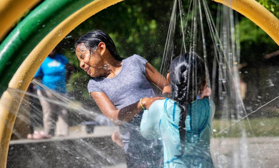 Melinda Chavez, 9, and Kendra Colorado, 6, splash in the water to beat the summer heat at the Forest Hills Sprayground in Durham, N.C. on Wednesday, July 6, 2022.