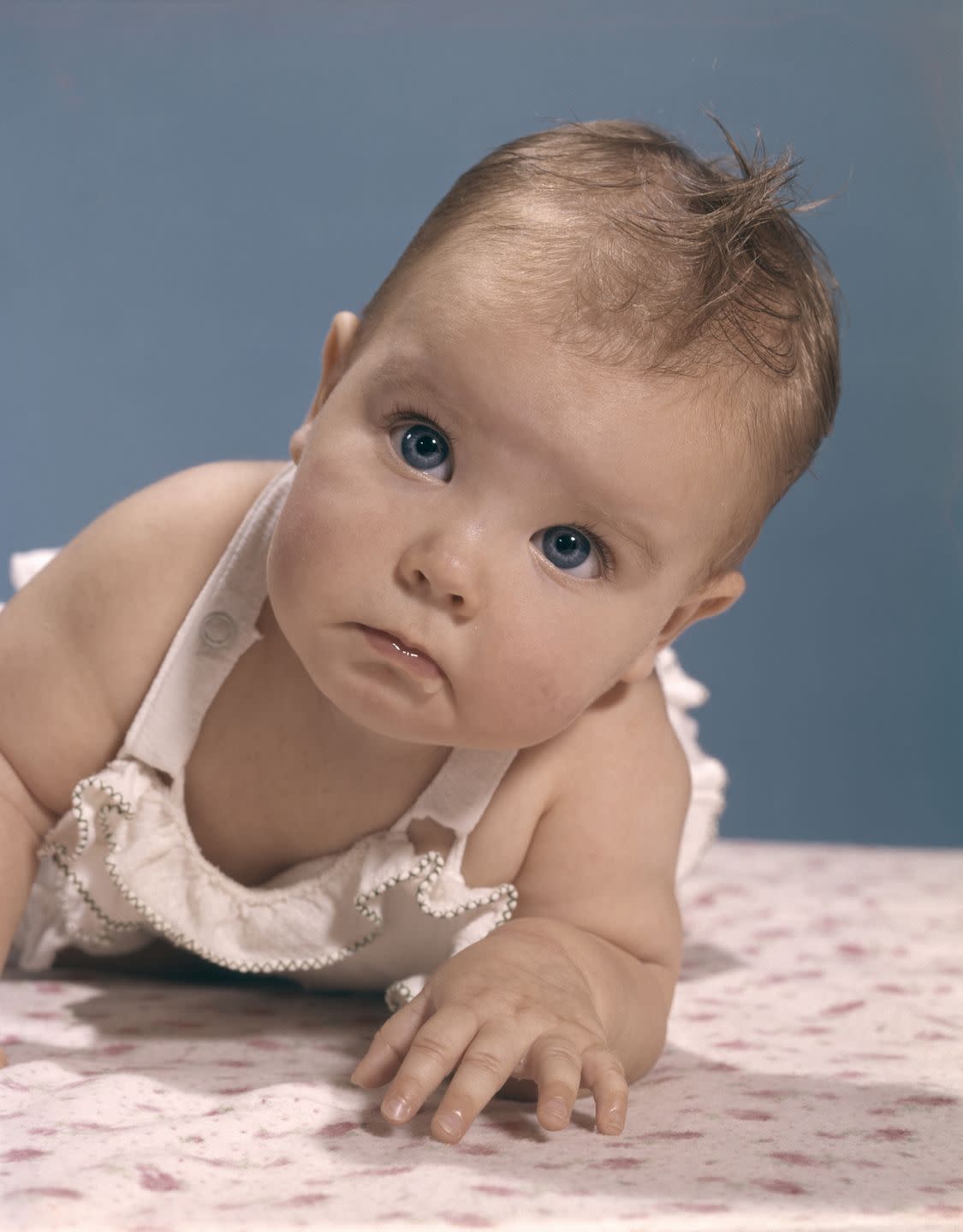 baby girl with blue eyes looking up at camera