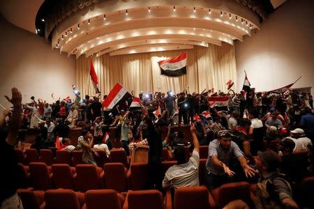 Followers of Iraq's Shi'ite cleric Moqtada al-Sadr are seen in the parliament building as they storm Baghdad's Green Zone after lawmakers failed to convene for a vote on overhauling the government, in Iraq April 30, 2016. REUTERS/Ahmed Saad