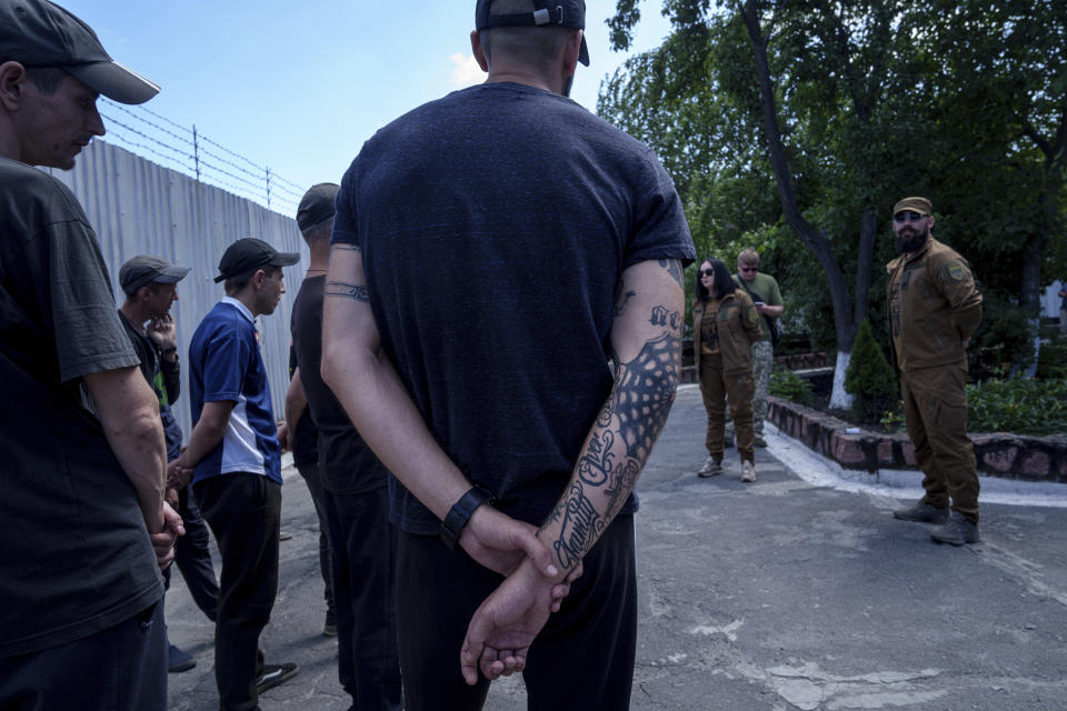 Prisoners listen to a Ukrainian sergeant of the Battalion Arey during an interview in a prison, in the Dnipropetrovsk region, Ukraine, Friday, June 21, 2024. Ukraine is expanding its military recruiting to cope with battlefield shortages more than two years into fighting Russia’s full-scale invasion. (AP Photo/Evgeniy Maloletka)