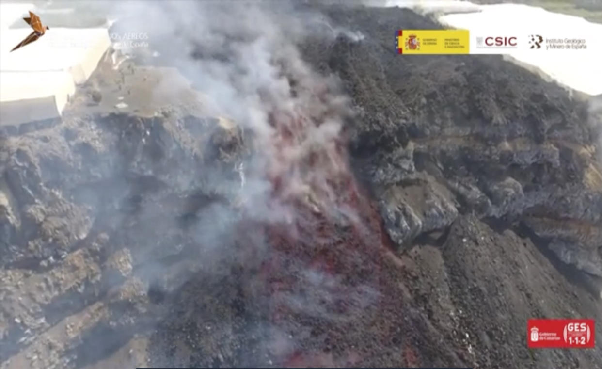 In this grab taken from Sept. 30, 2021 video made availbe by IGME-CSIC  (Geological Survey of Spain), a view of lava from the erupted volcano on the Canary island of La Palma. An erupting volcano on a Spanish island off northwest Africa has blown open another fissure on its hillside. The new fissure is the third to crack open since the Cumbre Vieja crater erupted on La Palma island on Sept. 19. Authorities were watching Friday to see whether lava from the new fissure would join the main flow that has reached the Atlantic Ocean. Officials are monitoring air quality along the shoreline. Sulfur dioxide levels in the area have risen but officials say they don't represent a health threat. (IGME-CSIC via AP)