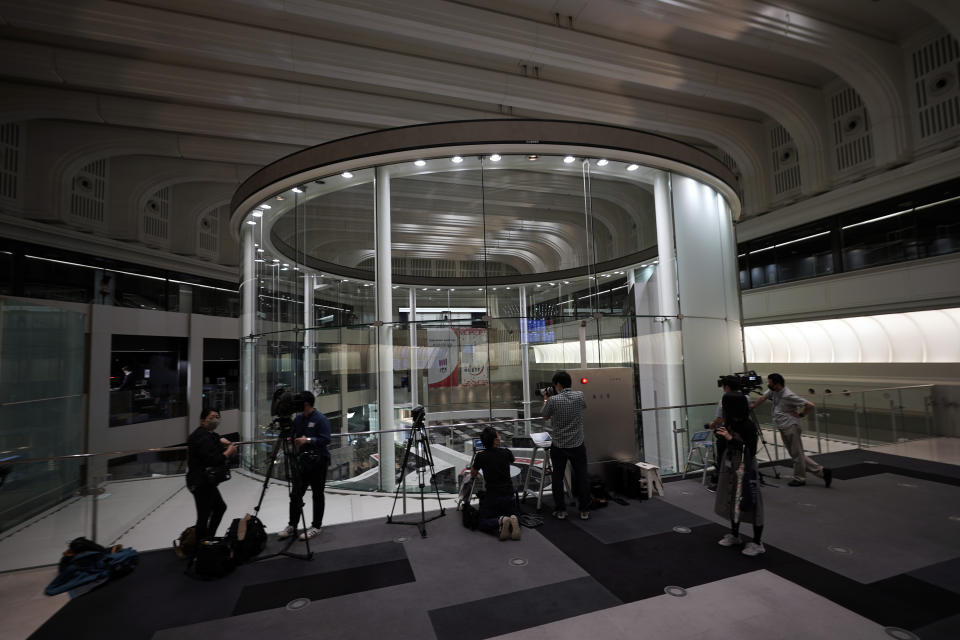 Members of media film a stock trading floor at Tokyo Stock Exchange Thursday, Oct. 1, 2020, in Tokyo. The Tokyo Stock Exchange temporarily suspended all trading due to system problem. (AP Photo/Eugene Hoshiko)