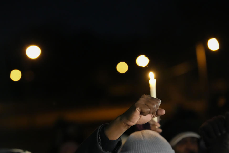 People hold up candles and fists at a candlelight vigil for Tyre Nichols, who died after being beaten by Memphis police officers, in Memphis, Tenn., Thursday, Jan. 26, 2023. (AP Photo/Gerald Herbert)