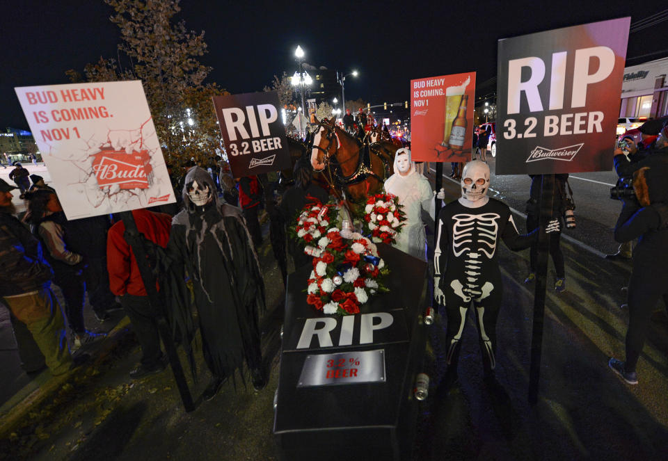 Budweiser's iconic Clydesdales make a special trip to Utah to celebrate the changing beer laws in the state, joined by a "ghoulish group of pallbearers," Wednesday, Oct. 30, 2019, for a funeral procession for Utah's last remaining 3.2 percent beer, in Salt Lake City, as the state prepares to start selling 4 percent alcohol-by-weight in grocery and convenience stores starting Friday. (Francisco Kjolseth/The Salt Lake Tribune via AP)