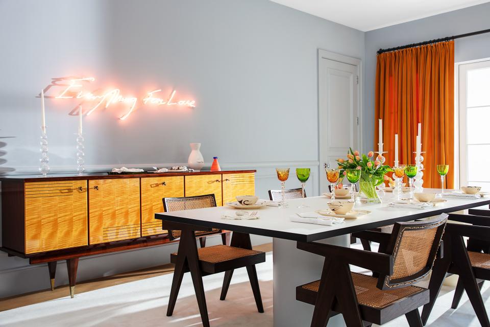 A Tracey Emin neon work lights up the dining room, with 1950s Pierre Jeanneret chairs at a table by Ana Kraš for Matter Made. Vintage credenza.