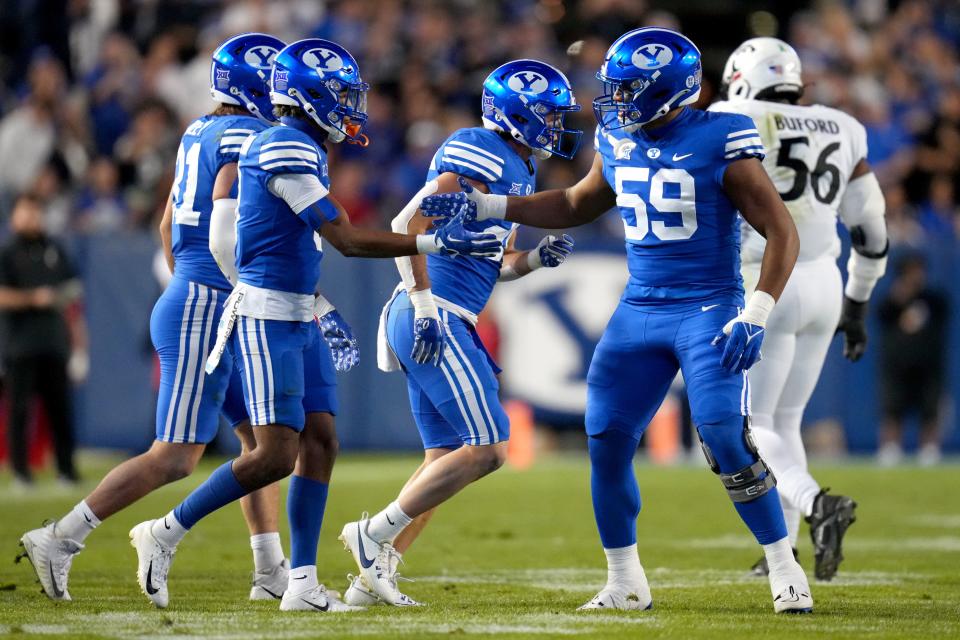 BYU defensive end Logan Lutui (59) congratulates cornerback Jakob Robinson (0) on a defensive stop in the first quarter against Cincinnati on Sept. 29 at LaVell Edwards Stadium in Provo, Utah.