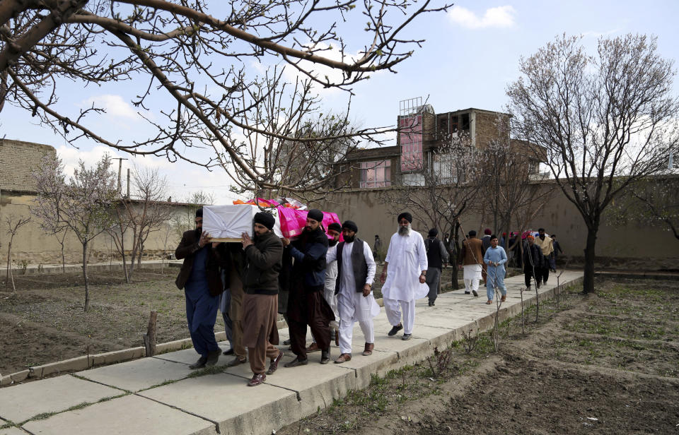 Afghan Sikh men carry coffins of their beloved ones during a funeral procession for those who were killed on Wednesday by a lone Islamic State gunman, rampaged through a Sikh house of worship, in Kabul, Afghanistan, Thursday, March 26, 2020. An explosive device disrupted Thursday's funeral service for 25 members of Afghanistan's Sikh minority community, killed in an attack by the Islamic State group on their house of worship in the heart of the capital. (AP Photo/Tamana Sarwary)