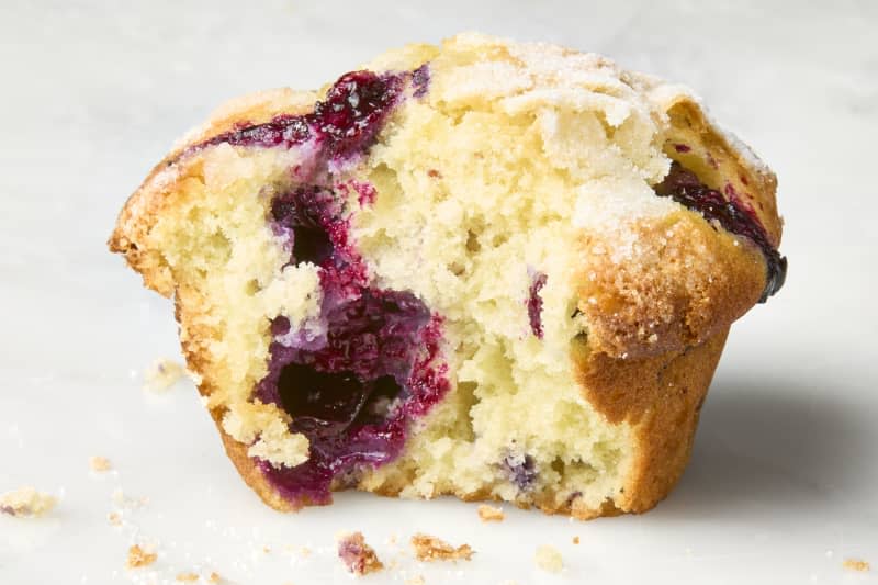 head on shot of the Hummingbird High blueberry muffin with a bite taken out of it.