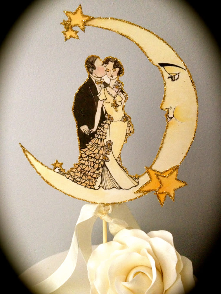 This photo provided by Jolie En Rose Vintage shows illustrator and designer Kris Shoemaker's 1920s style paper embellishments as a cake topper that she created for a vintage style wedding. It is available at www.etsy.com/JolieEnRoseVintage. She says, “The glamorous, celebratory nature of the Jazz Age evokes a romantic yet modern wedding theme that touches upon a playful nostalgia for this spirited era.” (AP Photo/Jolie En Rose Vintage, Kris Shoemaker )