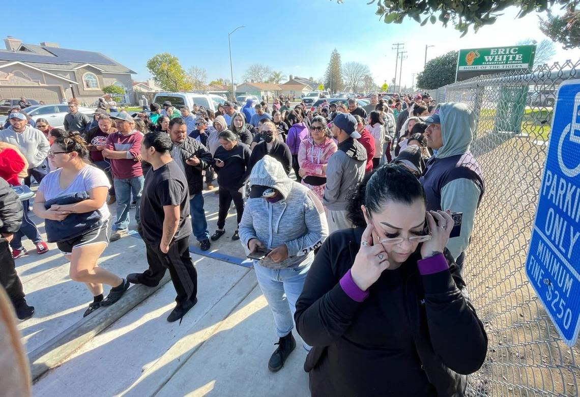 Family members of students at Eric White Elementary School wait outside the campus after it was locked down following the shooting of police officer about a block away in Selma, California, on Tuesday, Jan. 31, 2023.