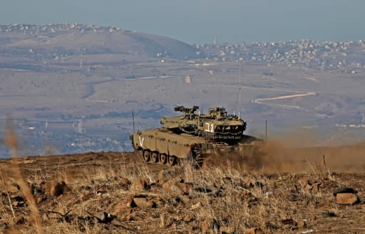 An Israeli armoured vehicle watches over Syrian government-held territory from the annexed Golan Heights