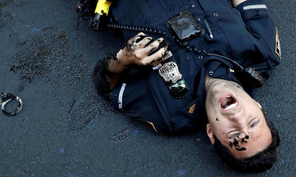 A police officer lies injured after attempting to detain a protester smearing paint on the Black Lives Matter mural.