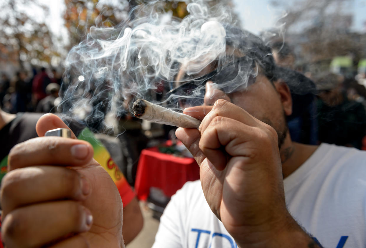 A demonstrator smokes marijuana during the "Cultivate Your Rights" march demanding its legalization, in Santiago, on May 18, 2019. (Photo by Martin BERNETTI / AFP)        (Photo credit should read MARTIN BERNETTI/AFP via Getty Images)