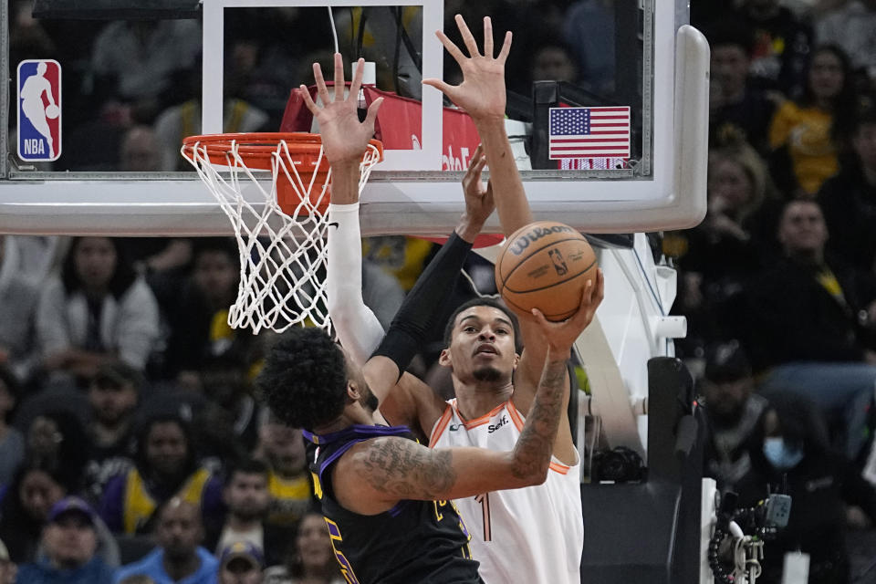 Los Angeles Lakers forward Christian Wood drives to the basket against San Antonio Spurs center Victor Wembanyama (1) during the first half of an NBA basketball game in San Antonio, Friday, Dec. 15, 2023. (AP Photo/Eric Gay)