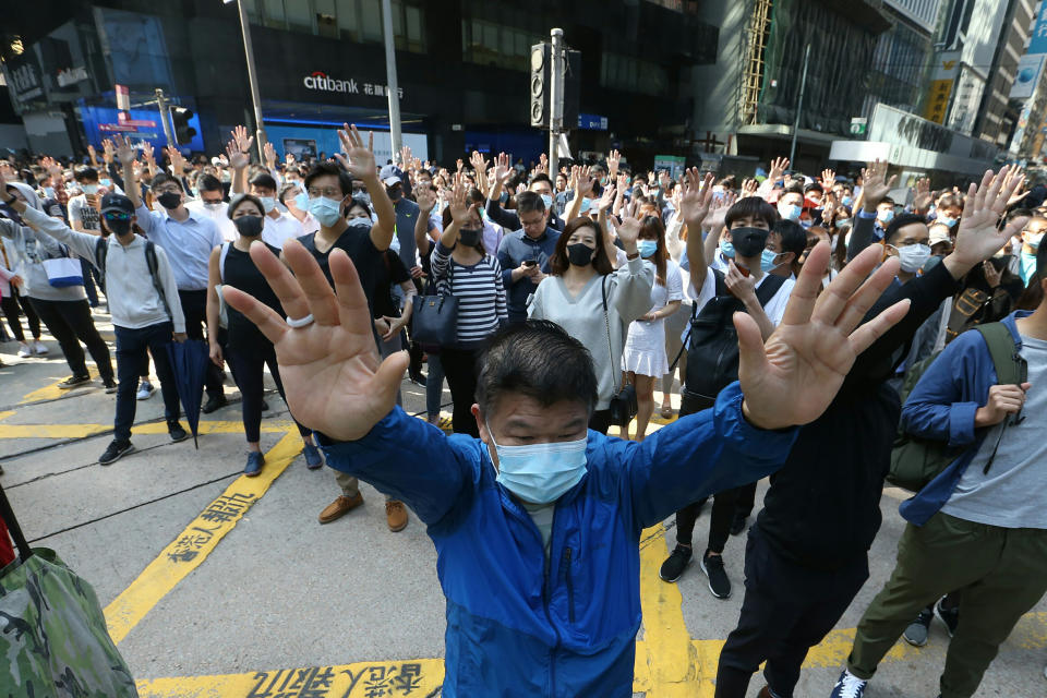 Demonstrators raise their hands during a protest in the financial district in Hong Kong, Friday, Nov. 15, 2019. Protesters who have barricaded themselves in a Hong Kong university partially cleared a road they were blocking and demanded that the government commit to holding local elections on Nov. 24. (AP Photo/Achmad Ibrahim)