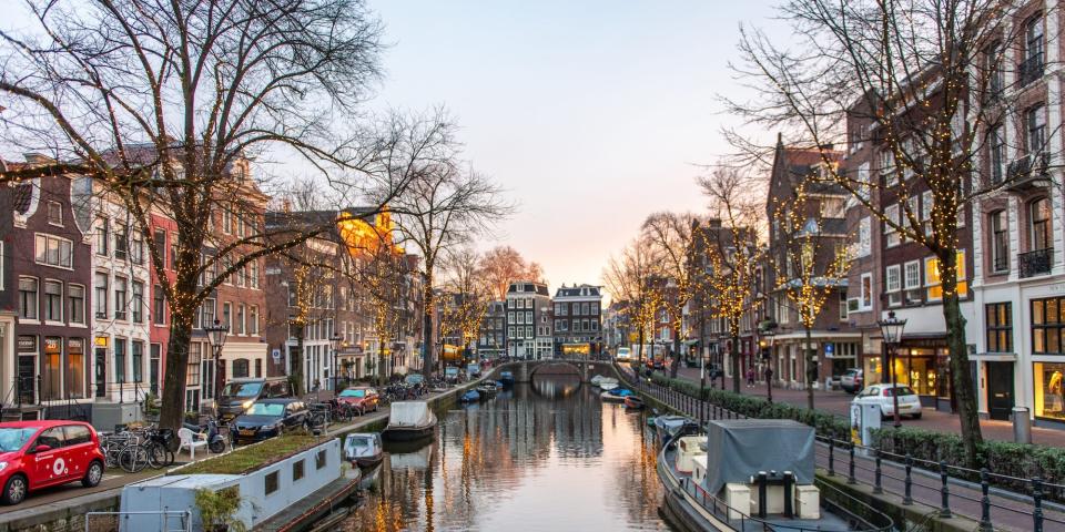 A view of a canal in central Amsterdam on a clear early evening.