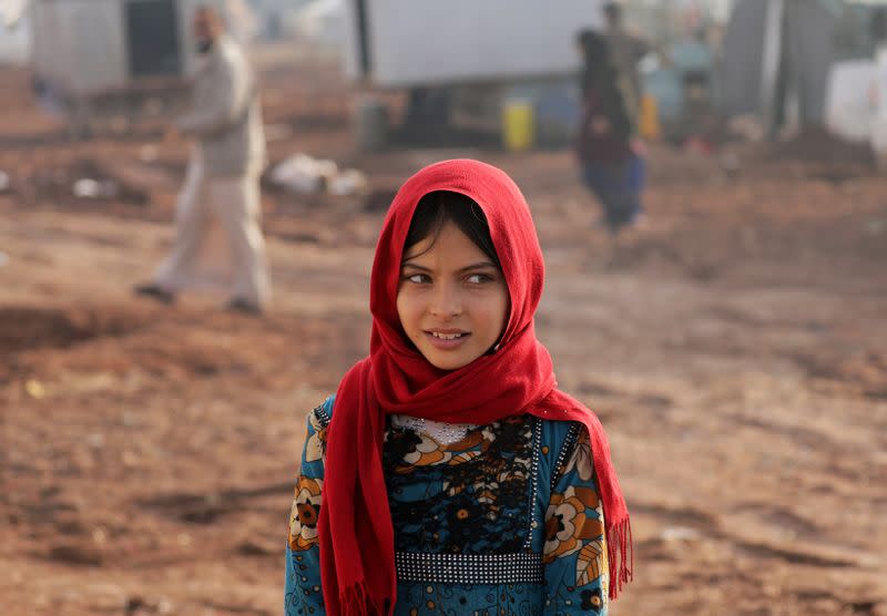 An internally displaced girl poses for a picture at a makeshift camp in Azaz