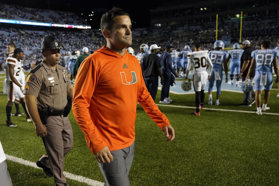 Miami head coach Manny Diaz, foreground, leaves the field following an NCAA college football game against North Carolina in Chapel Hill, N.C., Saturday, Oct. 16, 2021. (AP Photo/Gerry Broome)