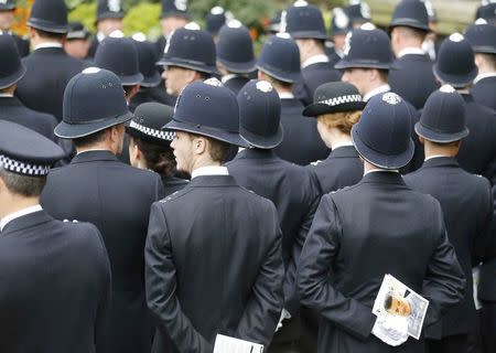 Police officers wait in silence for the coffin of PC Keith Palmer, the officer killed in the Westminster attack, to be carried into Southwark Cathedral for his funeral, in central London, Britain April 10, 2017. REUTERS/Frank Augstein/Pool