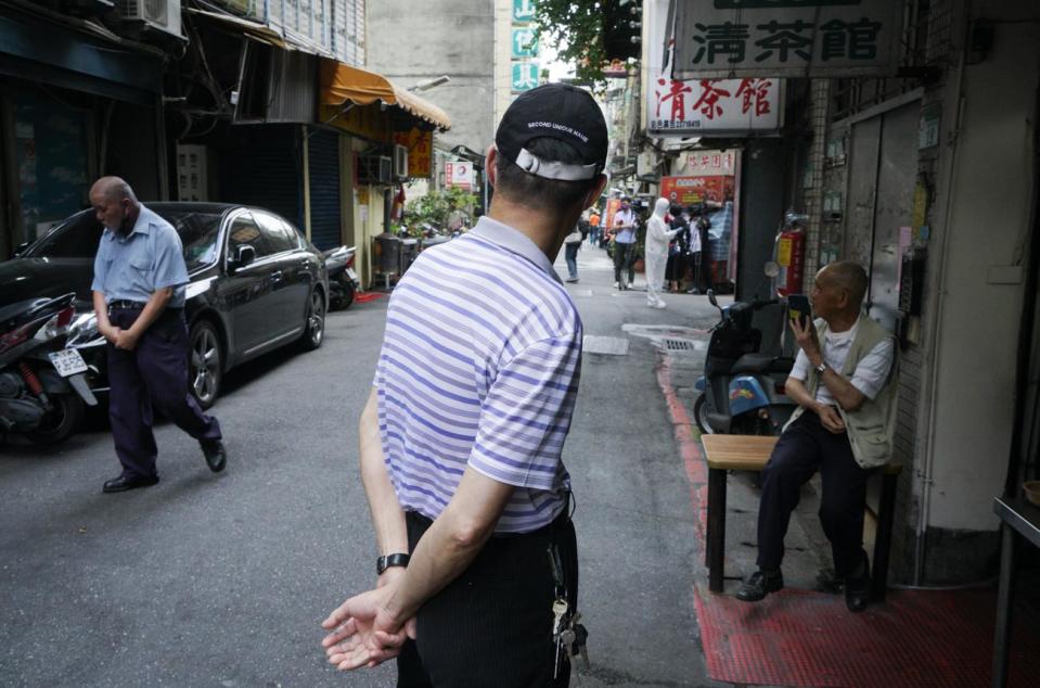 北市萬華區西園路的楓香清茶館傳出武漢肺炎案例後，吸引大批媒體記者到場採訪。圖為一些民眾站在清茶館外看媒體記者採訪。   圖：張良一/攝