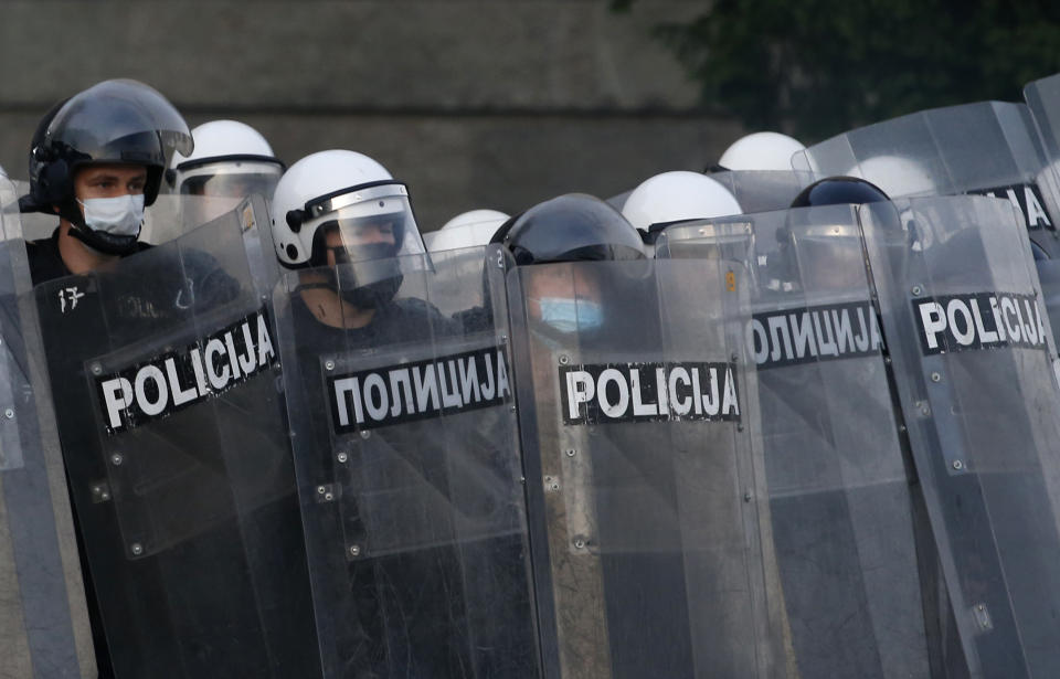 Serbian riot police shields themselves as they clash with protesters in Belgrade, Serbia, Wednesday, July 8, 2020. Serbia's president Aleksandar Vucic backtracked Wednesday on his plans to reinstate a coronavirus lockdown in Belgrade after thousands protested the move and violently clashed with the police in the capital. (AP Photo/Darko Vojinovic)