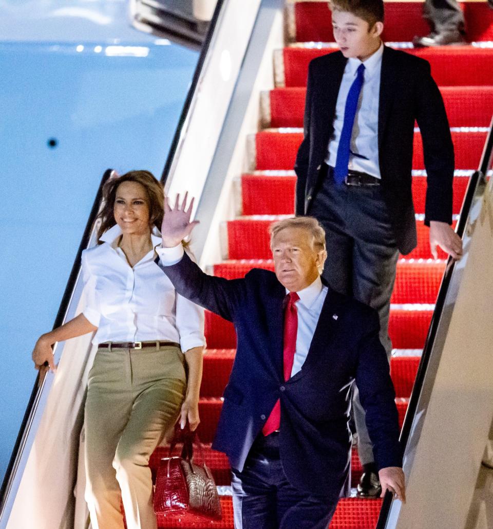 Then-President Donald Trump, accompanied by first lady Melania, and son Barron arrive on Air Force One at Palm Beach International Airport in December 2019.