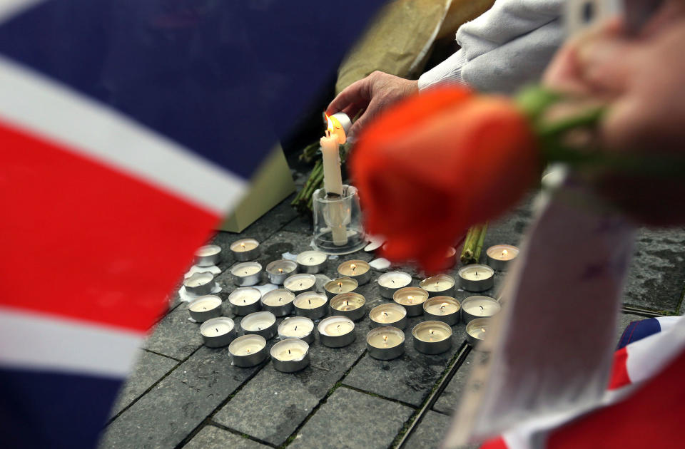 People light candles after a vigil for victims