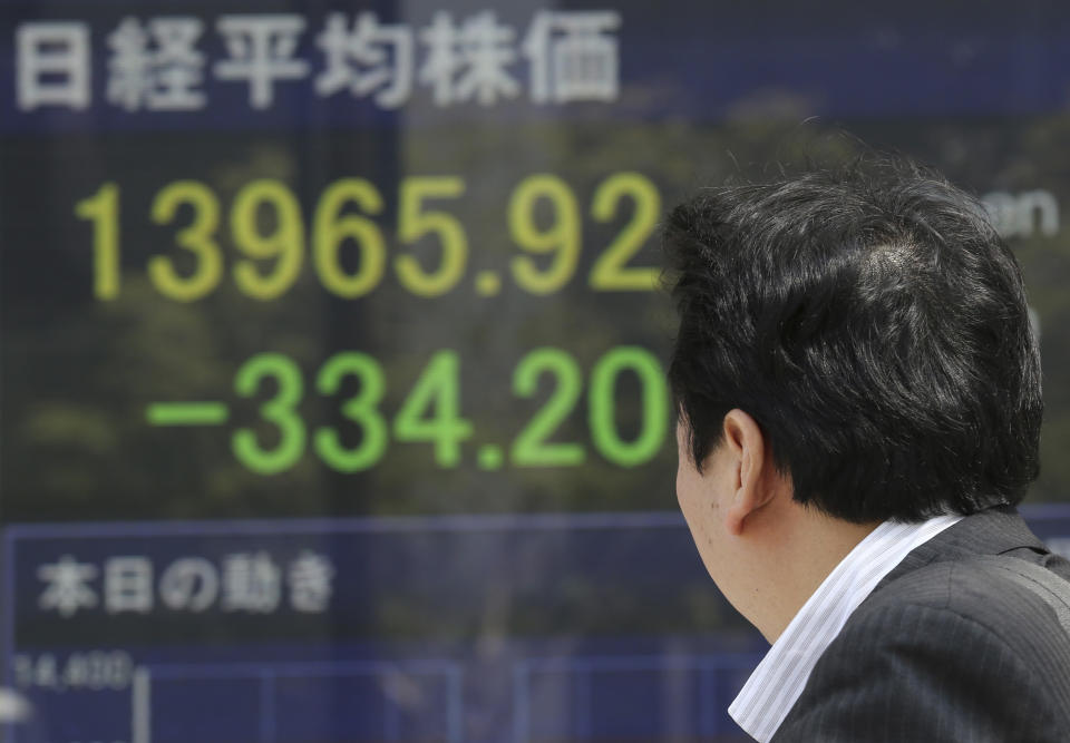 A man looks at an electronic stock board of a securities firm in Tokyo, Friday, April 11, 2014. Tokyo's Nikkei 225 stock average fell more than 400 points at one point in morning trading. (AP Photo/Koji Sasahara)