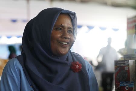 Salawati, an Acehnese survivor of the 2004 Indian Ocean tsunami, smiles as she speaks to her customers in Jakarta November 29, 2014. REUTERS/Pius Erlangga