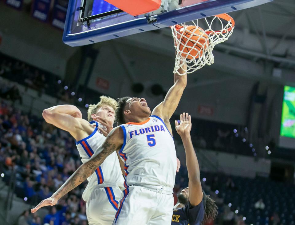 Florida Gators guard Will Richard (5) drops the ball in during a game against Merrimack College in Gainesville earlier this season. The Gators come to the RP Funding Center on Thursday for a game against East Carolina.