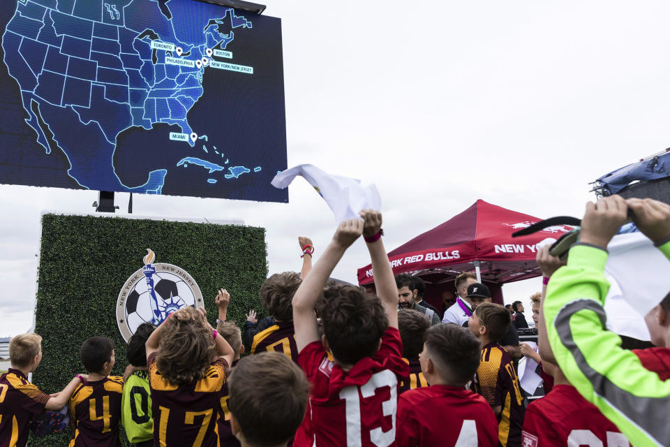 Children from the Massapequa, left, and Hoboken City youth soccer teams react to the announcement that East Rutherford, N.J., will be a FIFA World Cup 2026 host city, during a selection watch party at Liberty State Park in Jersey City, N.J., Thursday, June 16, 2022. (AP Photo/Stefan Jeremiah)