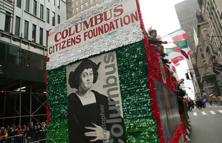 People wave flags from a decorated float during the 74th annual Columbus Day Parade in Manhattan, New York, U.S., October 8, 2018. Reuters/Shannon Stapleton