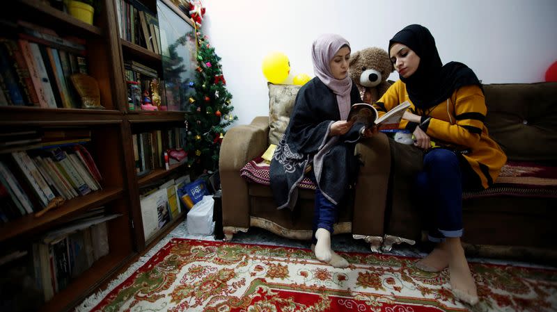 Jassem, 24, an Iraqi nurse reads a book with her friend in Baghdad
