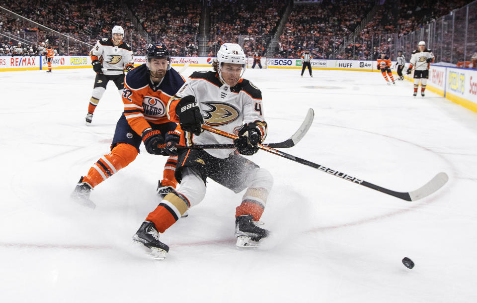 Anaheim Ducks' Trevor Zegras (46) and Edmonton Oilers' Brendan Perlini (42) compete for the puck during the second period of an NHL hockey game Tuesday, Oct. 19, 2021, in Edmonton, Alberta. (Jason Franson/The Canadian Press via AP)