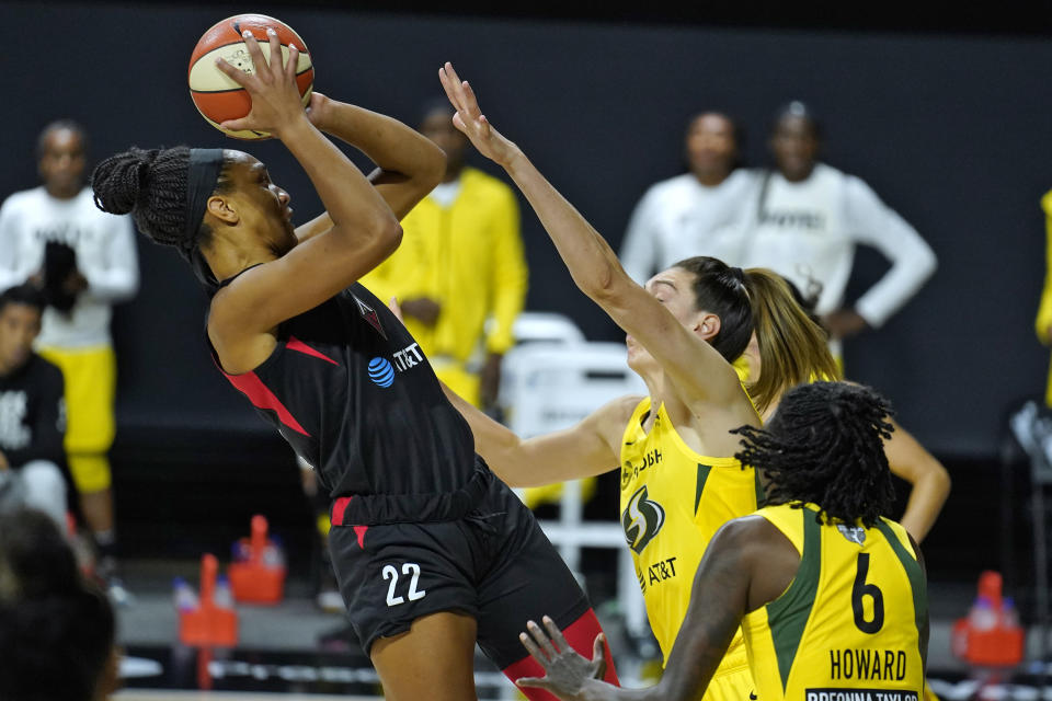 Las Vegas Aces center A'ja Wilson (22) shoots over Seattle Storm forward Breanna Stewart (30) and forward Natasha Howard (6) during the first half of Game 1 of basketball's WNBA Finals on Friday, Oct. 2, 2020, in Bradenton, Fla. (AP Photo/Chris O'Meara)