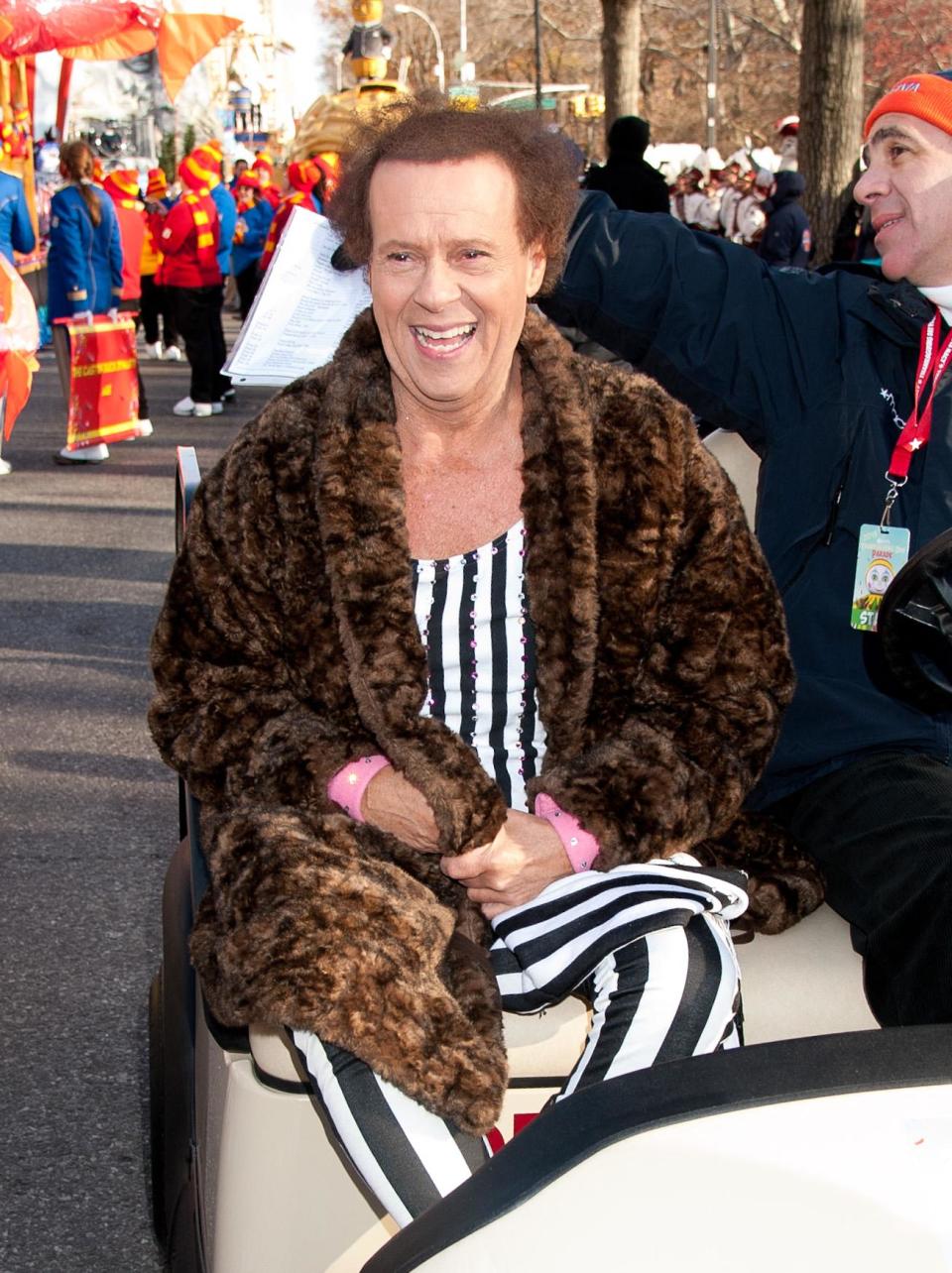 Richard Simmons wearing a brown jacket