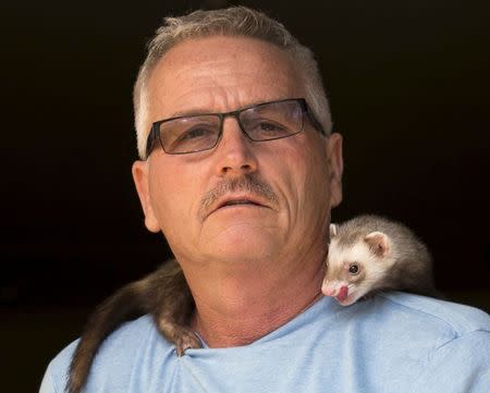 Pat Wright poses with Jethro, one of his three pet ferrets, at his home in La Mesa, California August 17, 2015. REUTERS/Mike Blake