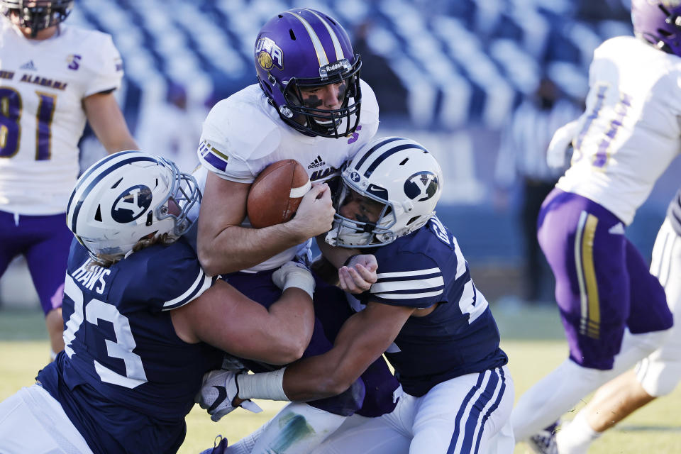 North Alabama quarterback Rett Files, center, is tackled by BYU defensive lineman Caden Haws, left and defensive back Tavita Gagnier (27) in the fourth quarter during an NCAA college football game Saturday, Nov. 21, 2020, in Provo, Utah. (AP Photo/Jeff Swinger, Pool)