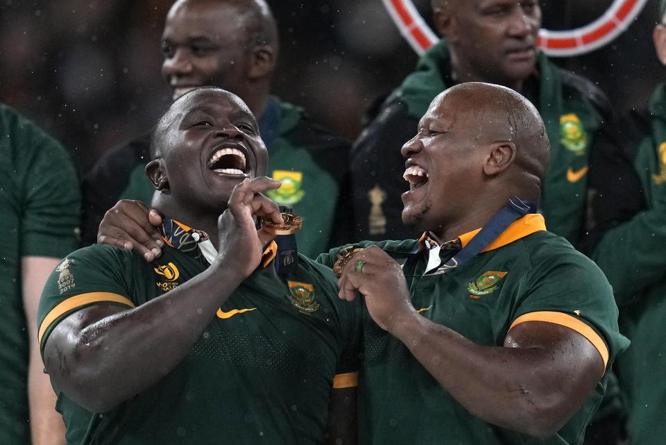 South Africa's Trevor Nyakane, left, and Mbongeni Mbonambi celebrate during presentation ceremony after the Rugby World Cup final match between New Zealand and South Africa at the Stade de France in Saint-Denis, near Paris Saturday, Oct. 28, 2023. South Africa won the match 12-11. (AP Photo/Thibault Camus)